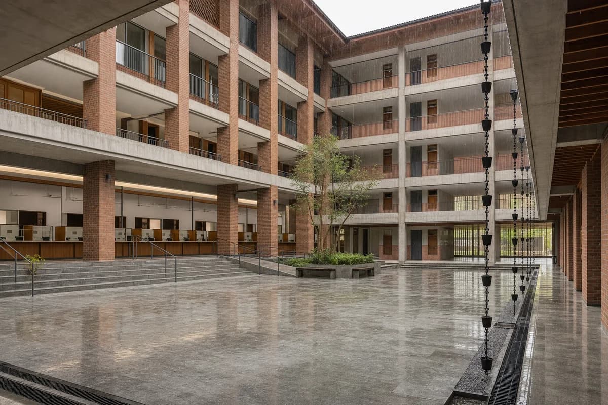 Brick municipal services court operating during steady monsoon rain.