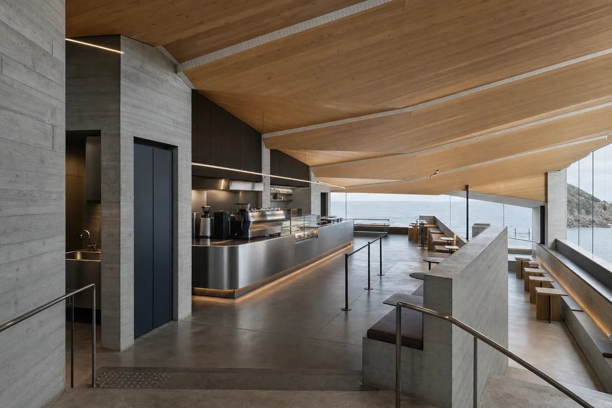 Cliffside cafe beneath folded timber roof plates with narrow ceramic fold ribs and a secondary sea loggia.