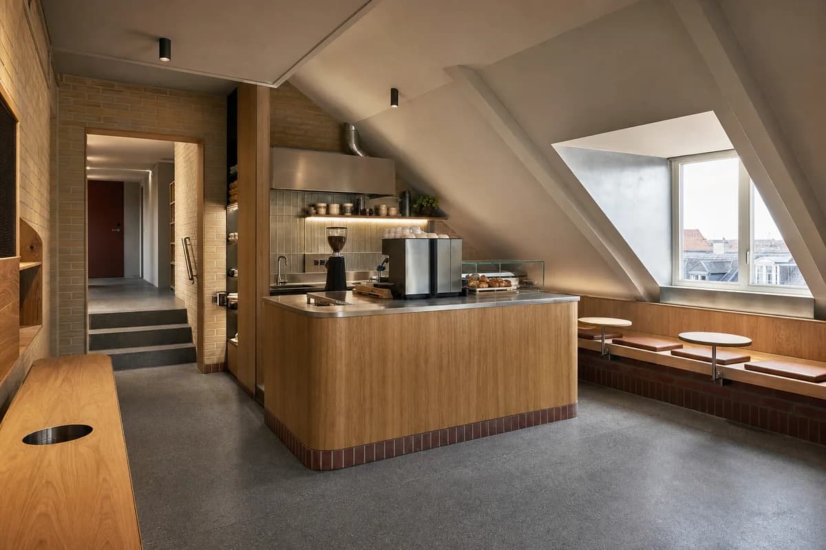 Attic Coffee Nook, micro cafe organized by a counter and six seats fitted beneath a regularized sloped roof.