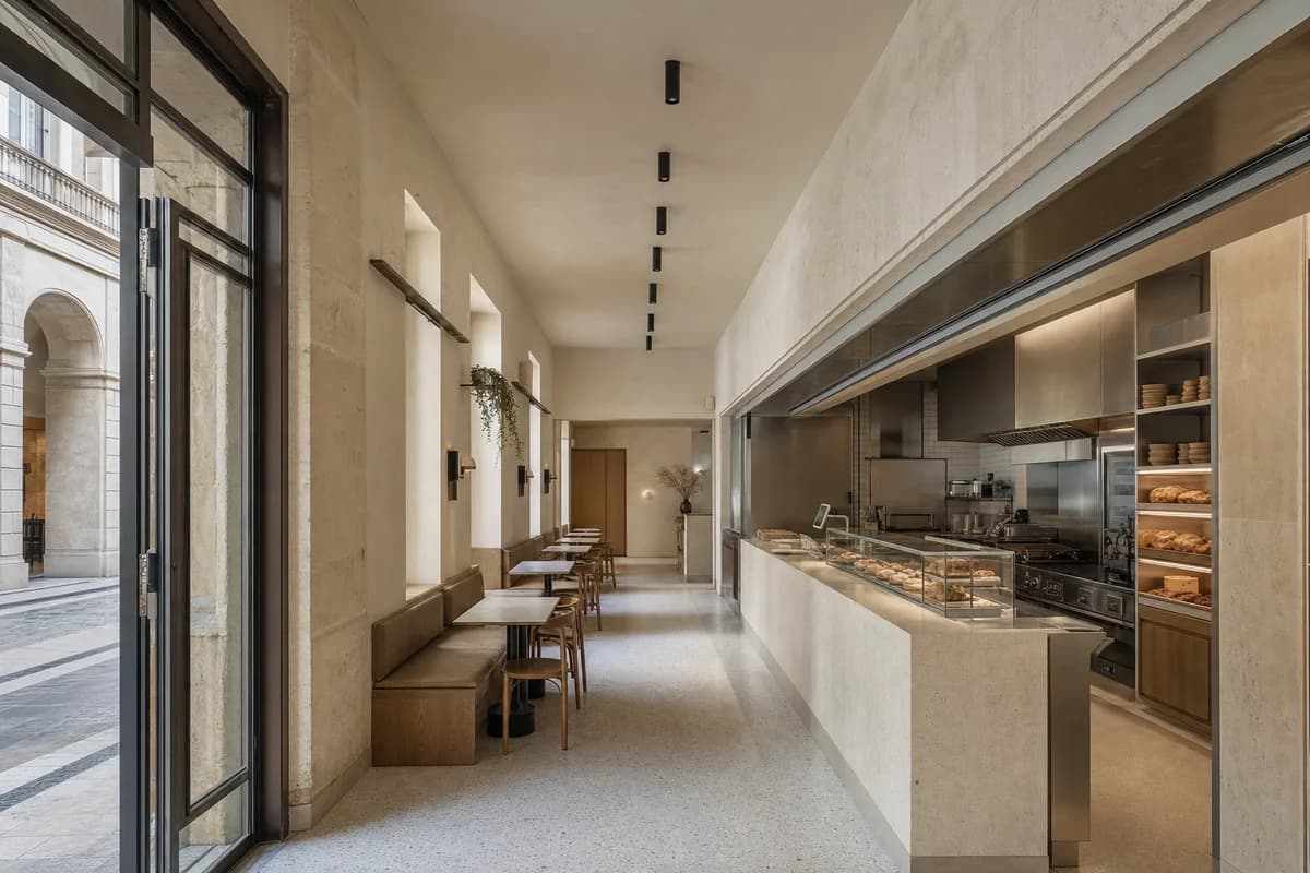 Passage Bakery Counter, bakery cafe organized by display and service folding into one thickened passage wall.