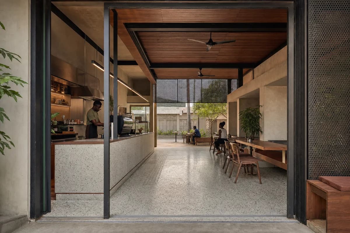 Veranda Coffee Commons, neighborhood cafe organized by a service bar anchoring a deep public veranda and inner court.