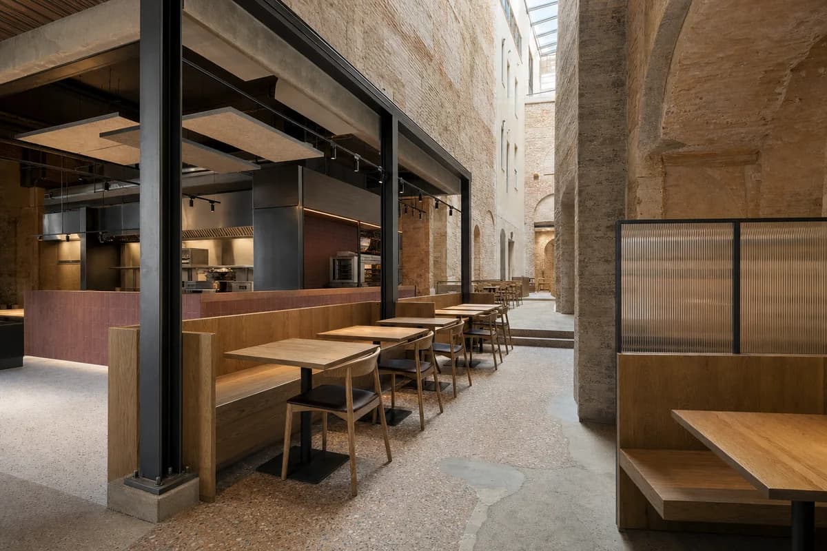 Unoccupied Barcelona archive atrium dining room with a freestanding darkened-steel service frame.