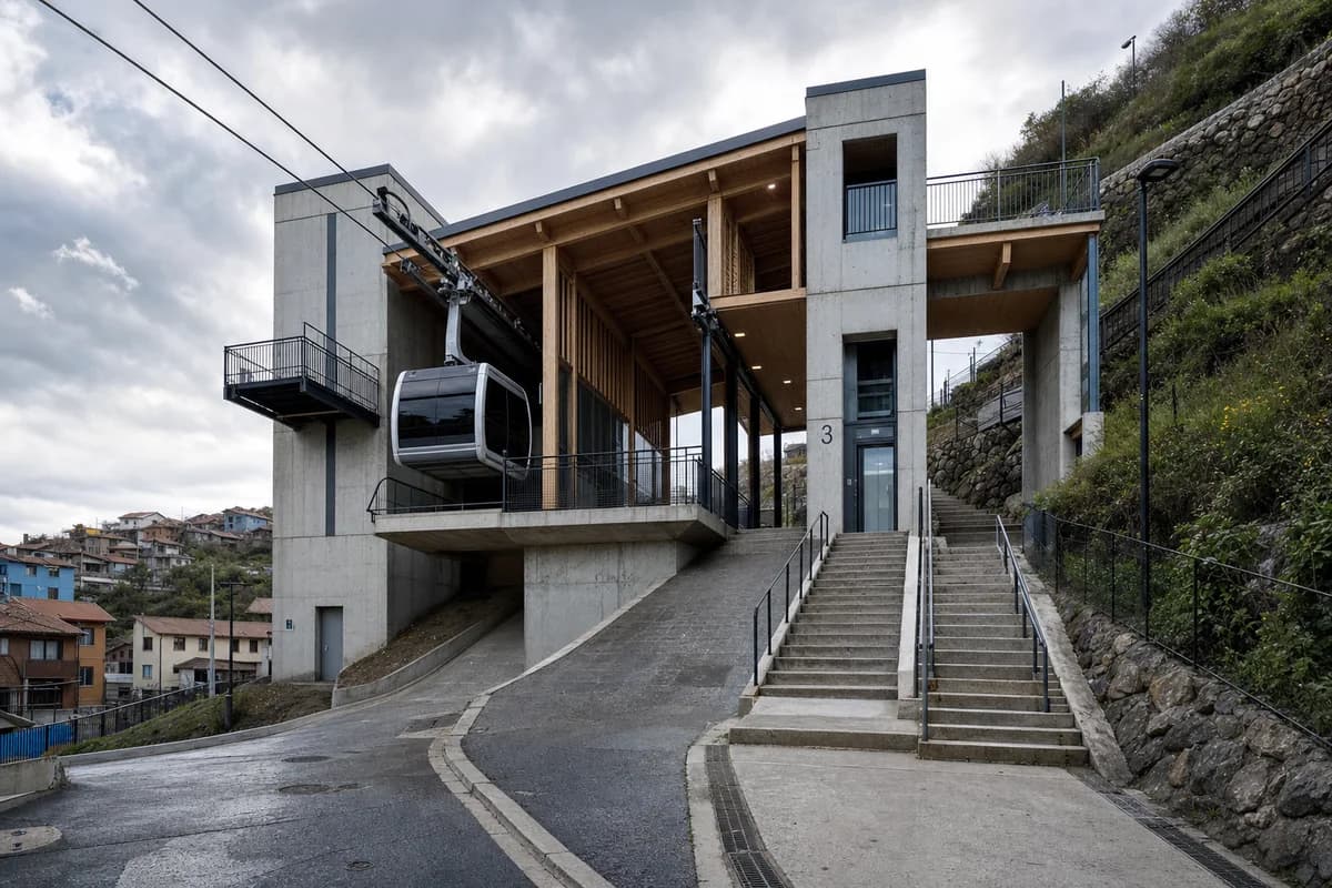 Timber cable-mobility concourse anchored by concrete hillside cores.
