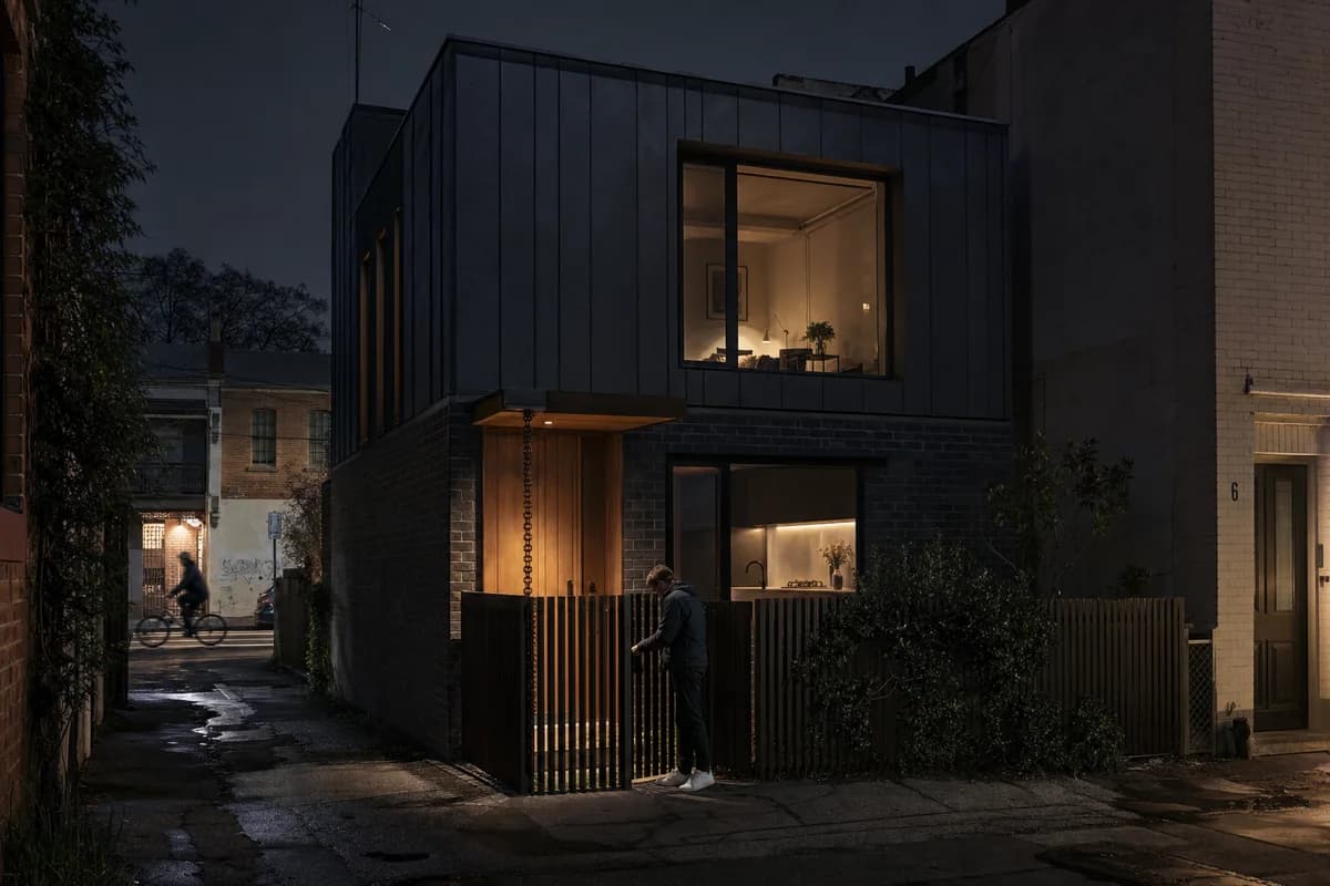 Second accepted render of the laneway house from the same 50mm lane camera, with identical night lighting, wet paving, geometry, and activity.