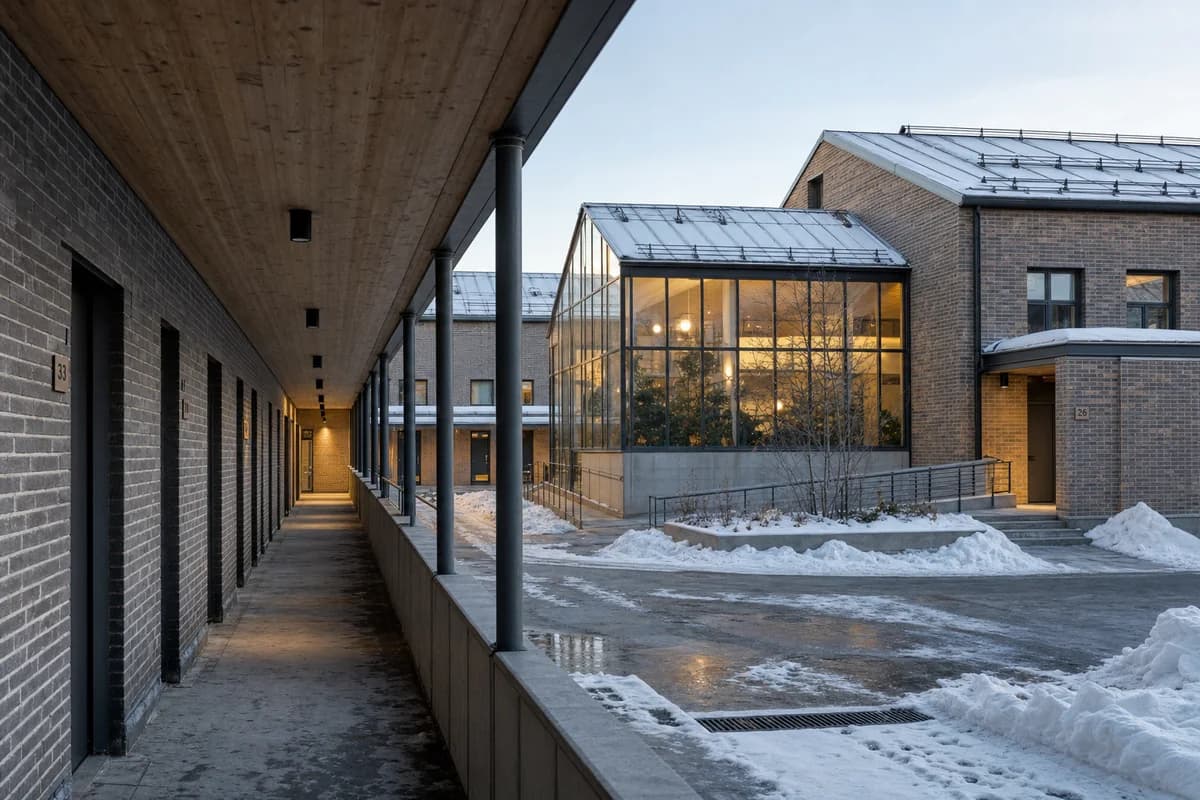 Unoccupied brick cohousing block with winter gardens and a sheltered snowy entrance.