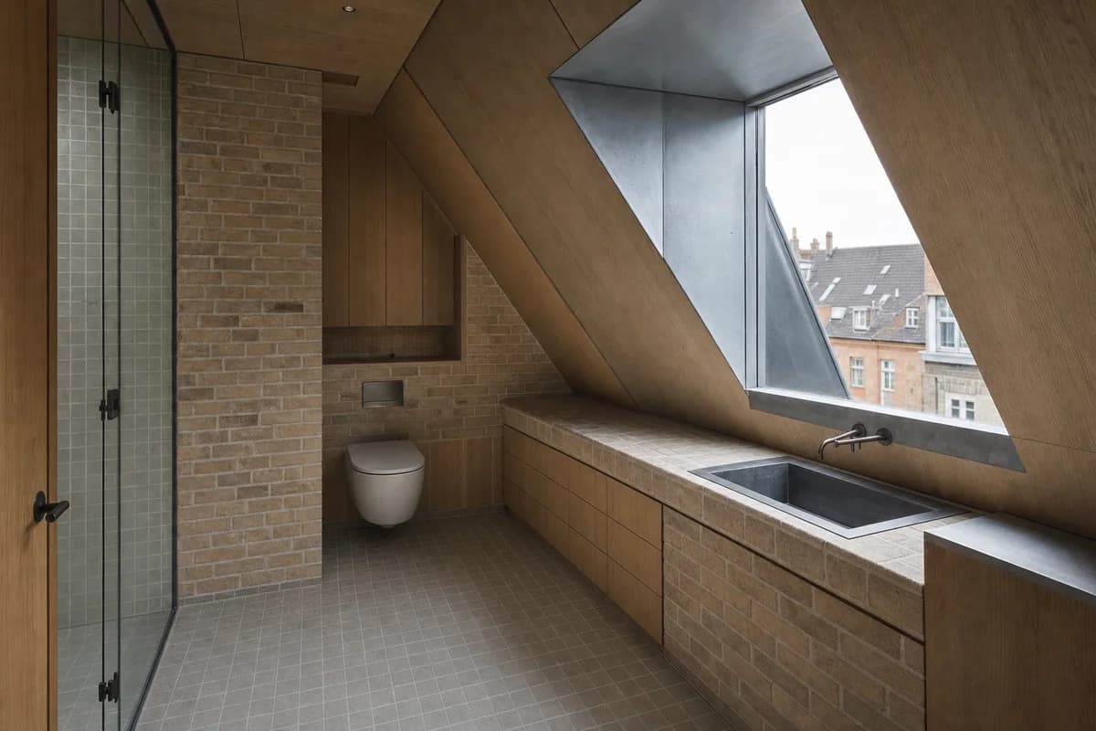 Compact Attic Bath, roof apartment bathroom defined by fixtures tucked beneath a sloped roof around one dormer.