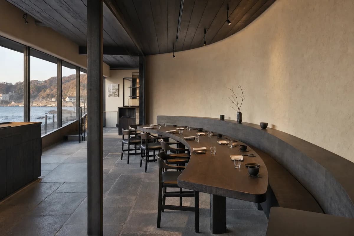 Charred-Timber Table Arc, furniture shaping coastal dining room with a curved table.