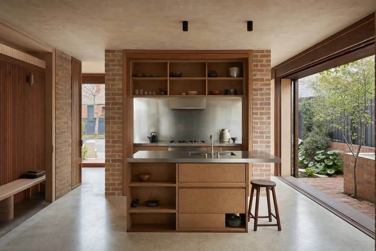 Garden-Wall Kitchen, courtyard house kitchen shaped by a freestanding service wall leaving daylight on both sides.