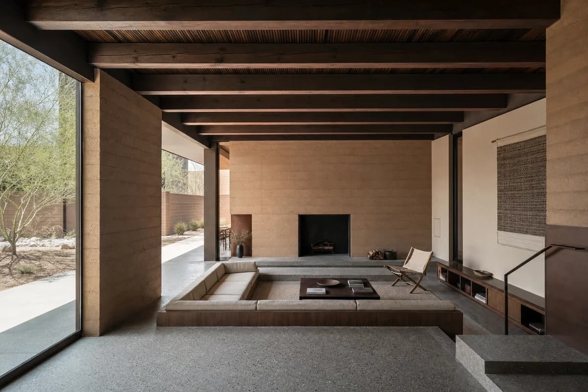 Sunken Thermal Room, desert-house living room organized by a half-sunken seating datum shaded by a heavy roof.