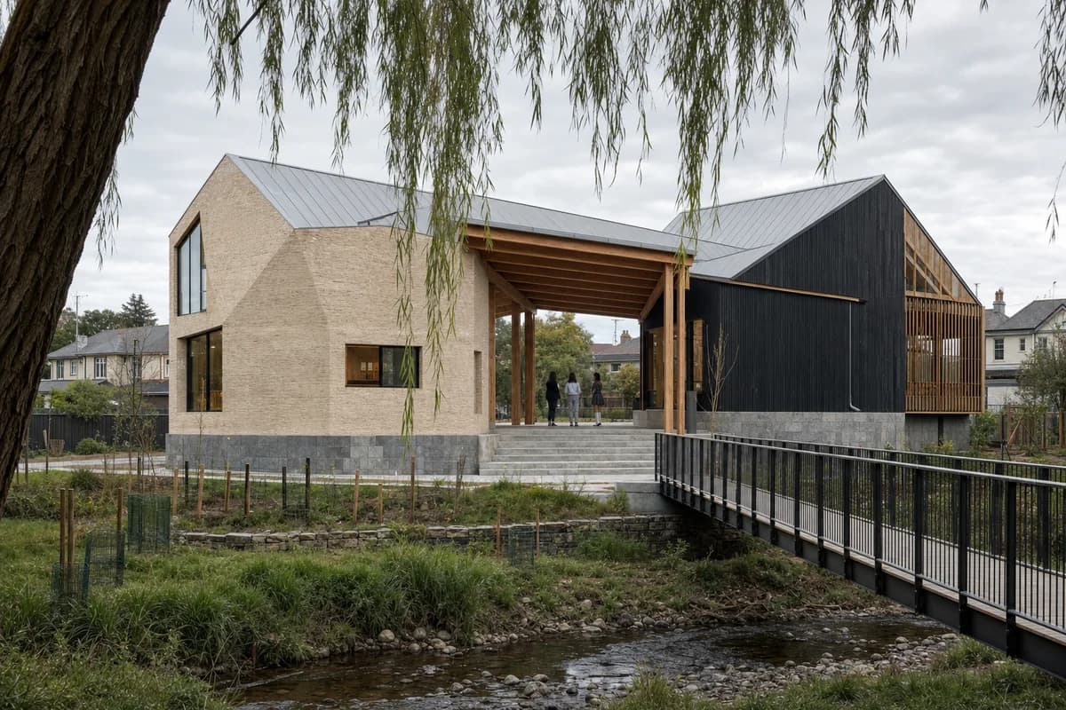 Brick and timber youth arts pavilion on a flood-resilient plinth beside a restored creek.