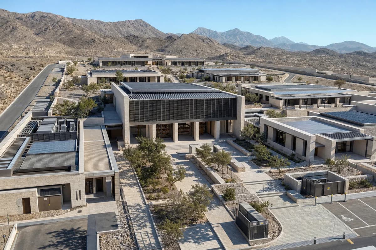 Bright sunny aerial of a Muscat research campus beneath a clear blue sky with warm direct sunlight and crisp courtyard shadows