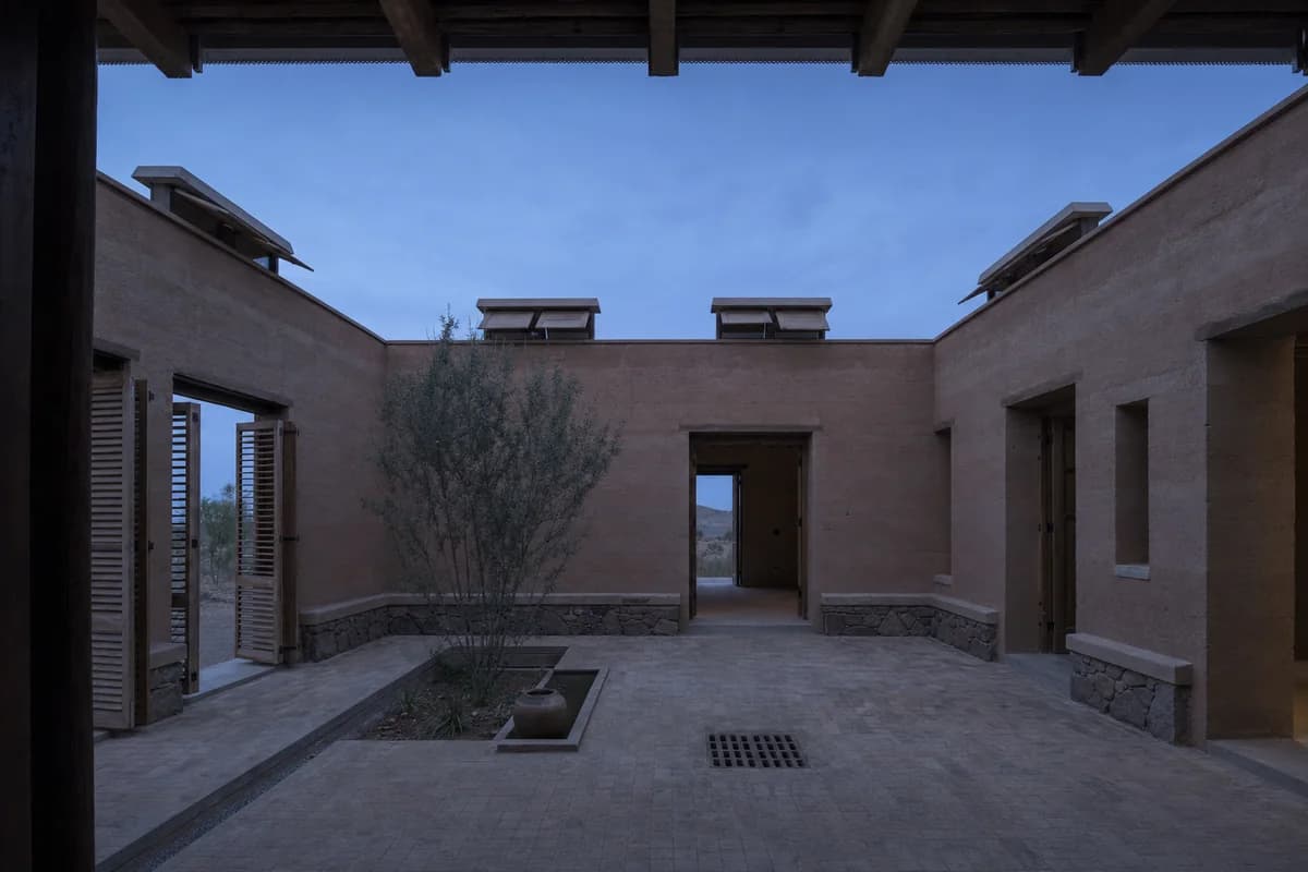 Earth-walled patio house opening for cool pre-sunrise ventilation.