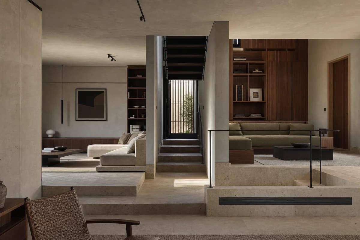 Split-Level Conversation Room, urban house living room organized by two distinct, fully furnished seating platforms at visibly different elevations framing a central stair and side-light slot.