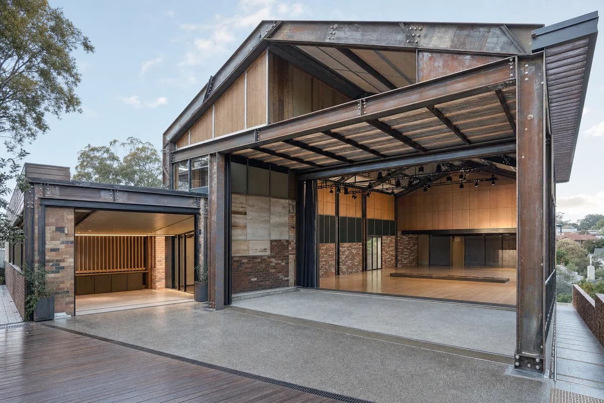 Unoccupied reclaimed-steel Melbourne chamber hall with a tall performance room and covered terrace