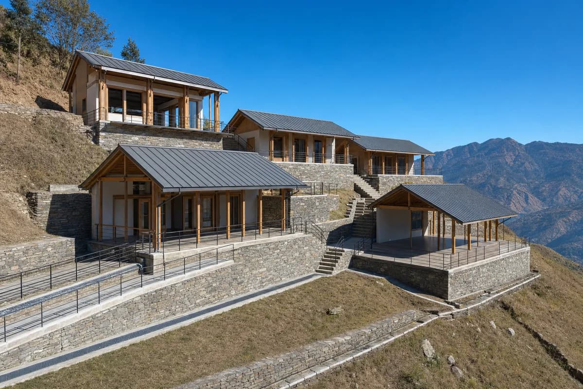 Bright sunny Himachal learning settlement under a clear blue sky with warm direct sunlight and crisp shadows across stone terraces