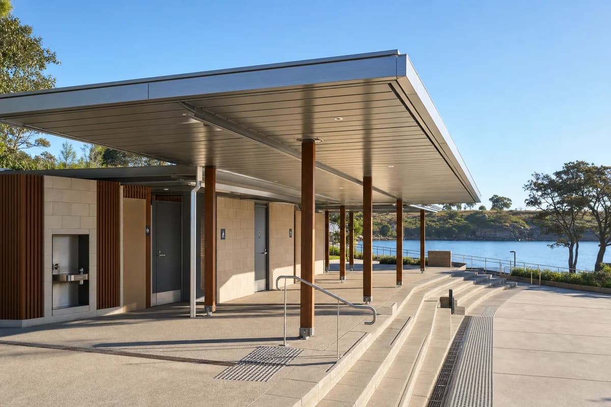 Bright sunny Sydney harbor pavilion beneath a clear blue sky with warm sunlight and crisp shadows.